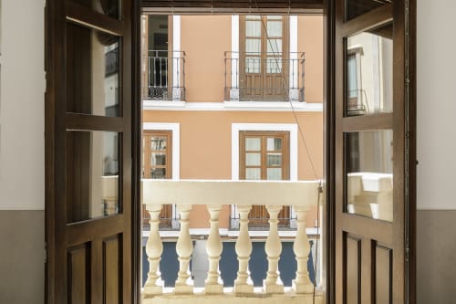 Vista desde la habitación de Pensión Castil en Granada mostrando arquitectura clásica española con balcones y fachada de terracota