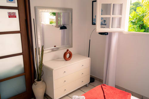 Chambre moderne avec commode blanche, miroir et vue sur mer au gîte Le Nid De Bellemont à Trois-Rivières