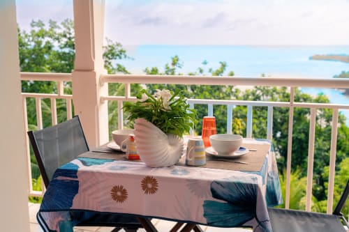 Petit-déjeuner sur la terrasse du gîte Le Nid De Bellemont à Trois-Rivières, vue sur l'océan bleu et la verdure luxuriante