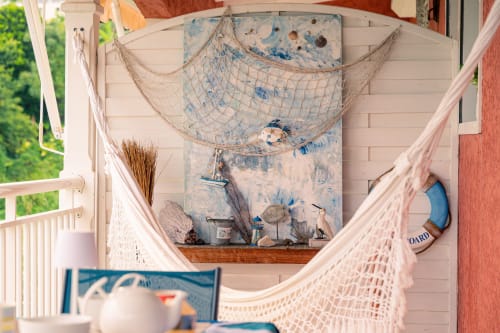 Balcon de chalet balnéaire avec filets de pêche, vue mer et décor nautique au Nid De Bellemont