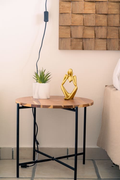 Table de chevet ronde en bois avec sculpture dorée et plante succulente dans une chambre contemporaine à Le Nid De