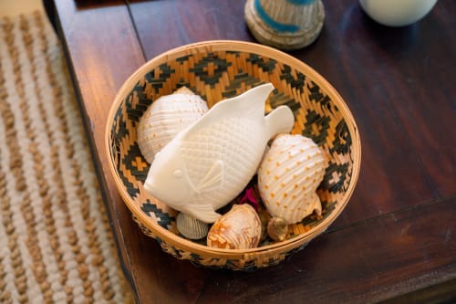 Panier tressé décoratif avec coquillages et figurine de poisson en céramique crème sur table en bois foncé au gîte Le Nid De Bellemont