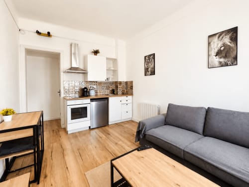 Séjour moderne avec cuisine, canapé gris et mobilier en bois à Nancy, France