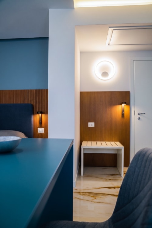 Camera moderna alle Camere di Totonno a Tropea con parete azzurra, rivestimenti in legno e illuminazione contemporanea