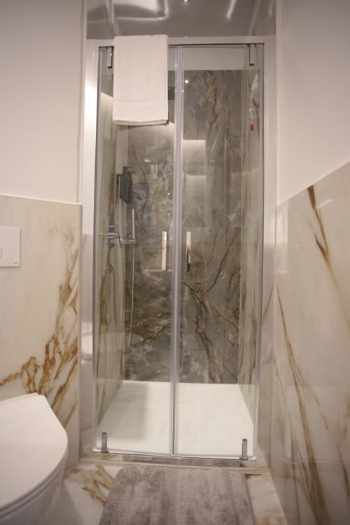 Bagno moderno con piastrelle in marmo nell'appartamento Calata di Forgiari presso Totonno's Rooms, Tropea