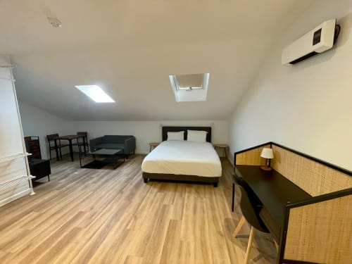 Studio spacieux à l'Hôtel d'Angleterre à Vittel avec lit, coin salon et mobilier contemporain