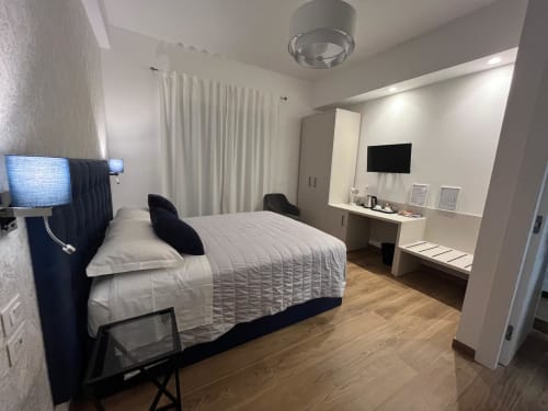 Camera moderna a Maritza Guest House a Roma con letto queen, TV a schermo piatto, scrivania e vista sulla città