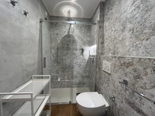 Bagno moderno presso la Maritza Guest House Roma con doccia walk-in, toilette e piastrelle grigie texturizzate