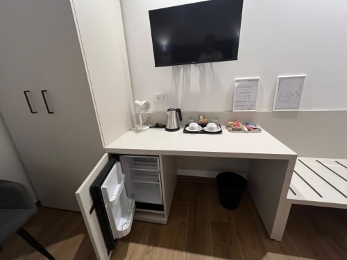 Angolo cottura moderno nella camera Maritza Guest House Roma con scrivania, TV, frigorifero e comfort