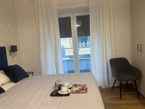 Camera moderna a Maritza Guest House a Roma con vista sulla città, letto matrimoniale, vassoio di benvenuto e accesso al balcone