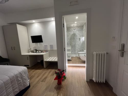 Camera moderna presso Maritza Guest House Roma con bagno en-suite, scrivania di lavoro e vista sulla città