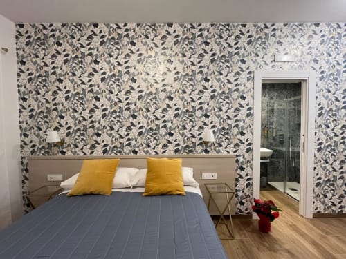 Camera moderna presso Maritza Guest House Roma con carta da parati botanica, biancheria blu, cuscini gialli e bagno interno