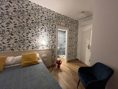 Camera moderna della Maritza Guest House Roma con carta da parati decorata, pavimenti in legno e balcone con vista sulla città
