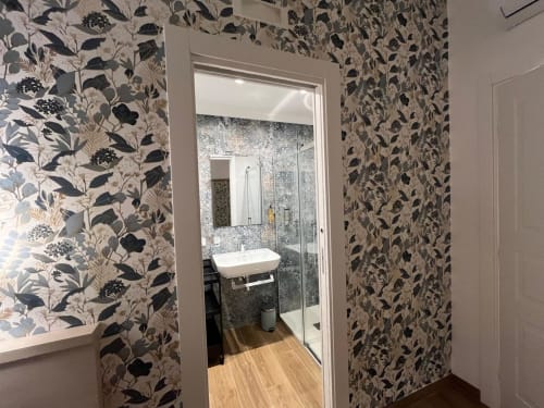 Bagno moderno della Maritza Guest House Roma con carta da parati botanica, doccia a pioggia e lavabo d'appoggio