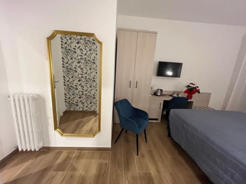 Camera moderna presso la Maritza Guest House a Roma con letto, scrivania, specchio e vista sulla città