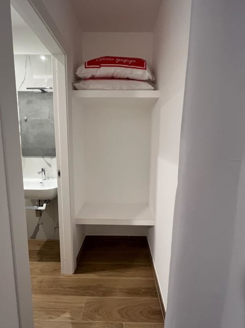 Camera Maritza Guest House Roma con scaffalature integrate, cuscini e bagno privato con pavimentazione in legno