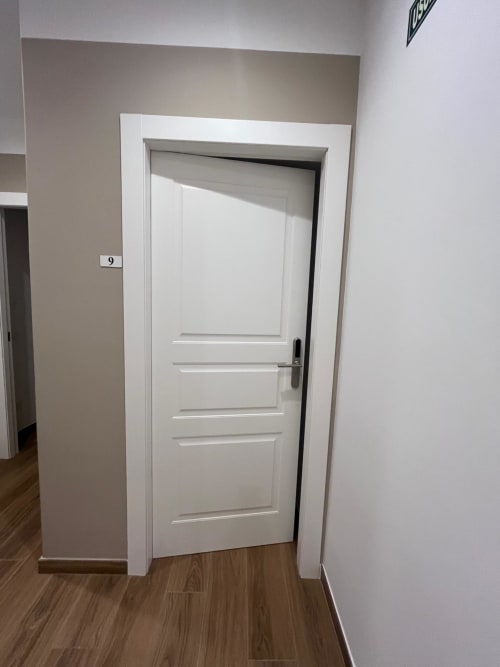 Porta a pannelli bianchi nella Camera 9 della Maritza Guest House di Roma, con pavimentazione in legno e pareti neutre