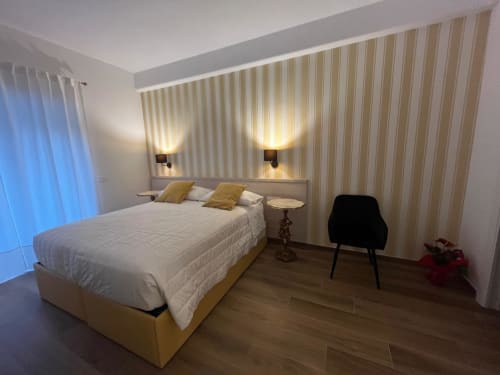 Camera moderna della Maritza Guest House Roma con letto matrimoniale, parete a righe, illuminazione soffusa e vista sulla città