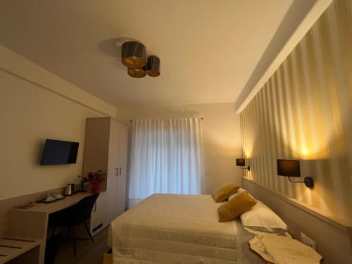 Camera moderna a Maritza Guest House Roma con letto queen, vista sulla città, scrivania da lavoro e illuminazione calda