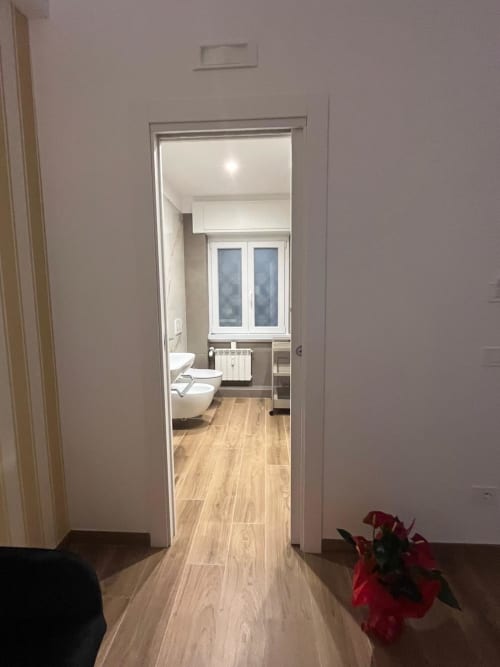 Corridoio moderno della Maritza Guest House Roma che conduce a bagno contemporaneo con pavimento in legno