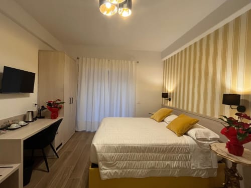 Camera moderna alla Maritza Guest House Roma con letto matrimoniale, scrivania di lavoro, tende con vista città e illuminazione calda