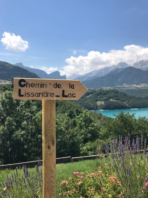 Panneau en bois du Chemin de la Lissandre-Lac avec lac turquoise et montagnes alpines près de l'Hôtel le tilleul, Corps