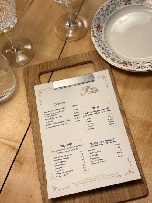 Menu du restaurant de l'Hôtel l'Ange à Niedermorschwihr présentant desserts, digestifs et boissons chaudes sur table en bois