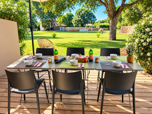 Espace de repas extérieur à la villa ALMA ROSSA à Lecci avec table, chaises et vue pittoresque sur le jardin