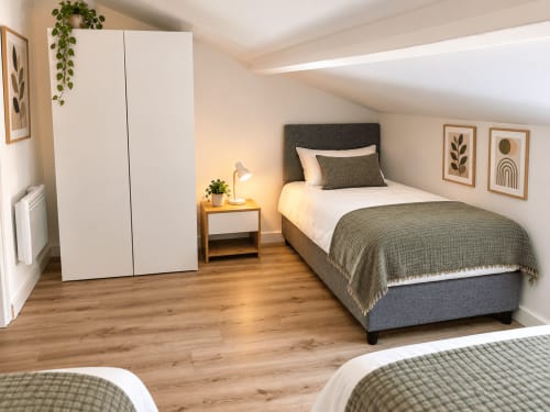 Chambre moderne de la villa ALMA ROSSA à Lecci avec lits jumeaux, tête de lit grise, parquet, armoire blanche et style contemporain