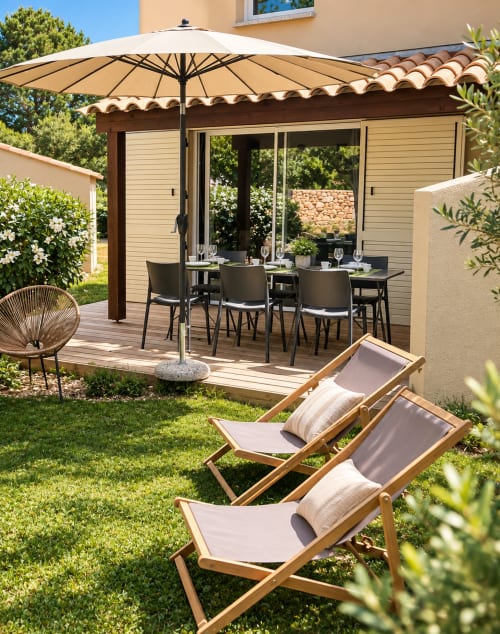Terrasse de la villa ALMA ROSSA avec transats, coin repas sous parasol et jardin luxuriant à Lecci