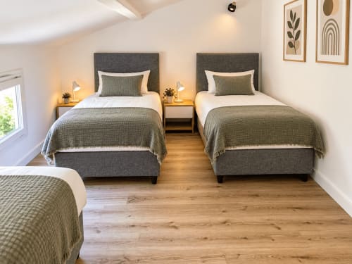 Chambre double lumineuse à la villa ALMA ROSSA à Lecci avec lits gris capitonnés, parquet et décoration moderne