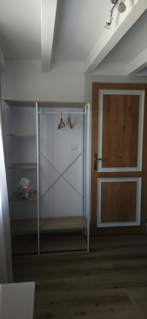Armoire de la chambre La Romantique à La Cour d'Arblade, chambres d'hôtes à Arblade-le-Haut, France, avec placard métallique blanc et porte d'entrée en bois