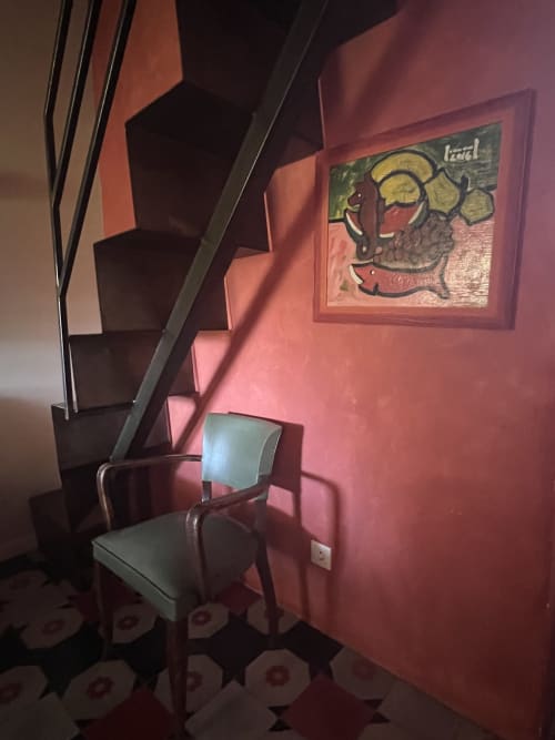 Angolo accogliente al Clos BB di Saint-Cyr sur Mer con pareti rosa, quadri incorniciati, sedia e scala