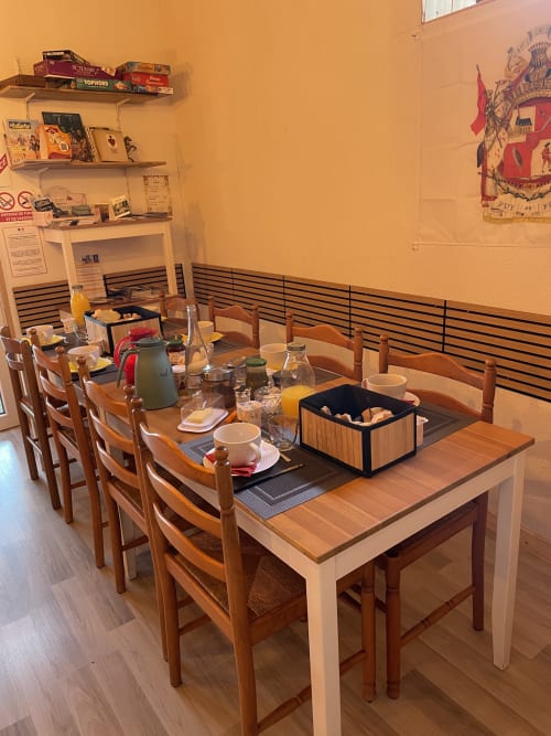 Salle à manger du gîte Le Petit Moulin à Pouzauges avec tables en bois, chaises en paille et décoration champêtre