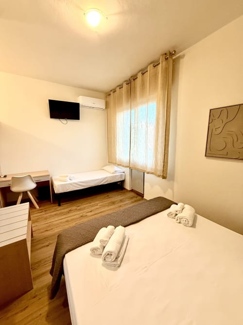 Camera tripla Hotel Il Mulino con letto matrimoniale, singolo, parquet, TV, scrivania e accesso balcone a Casalgrande