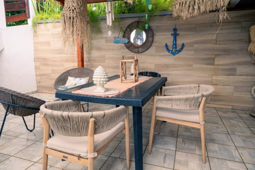 Terrasse de chalet côtier avec table à manger, chaises tressées et décor nautique au Nid De Bellemont, Trois-Rivières