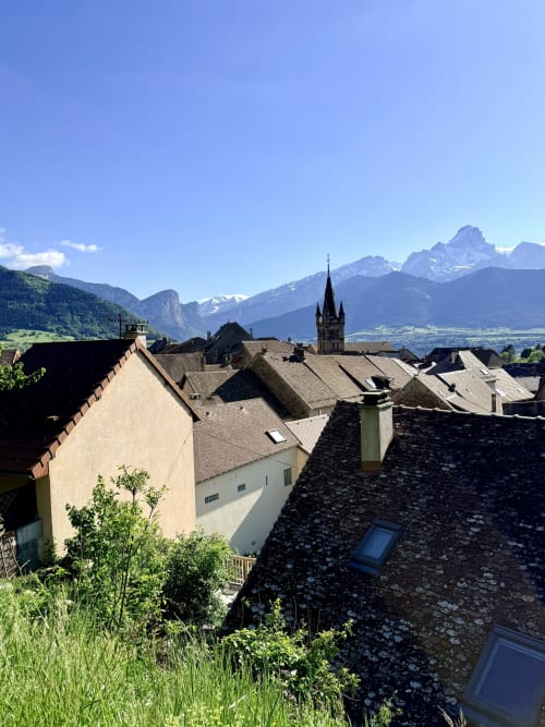 Vue depuis la terrasse de l'Hôtel le Tilleul surplombant le village de Corps, les Alpes et le clocher de l'église