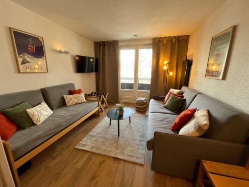 Séjour douillet pour 4 personnes à Vars avec canapés gris, télévision et décoration aux accents montagnards