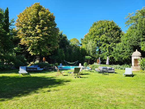 Jardin ensoleillé du gîte Logis des Tourelles à Cognac avec pelouse, piscine et arbres luxuriants