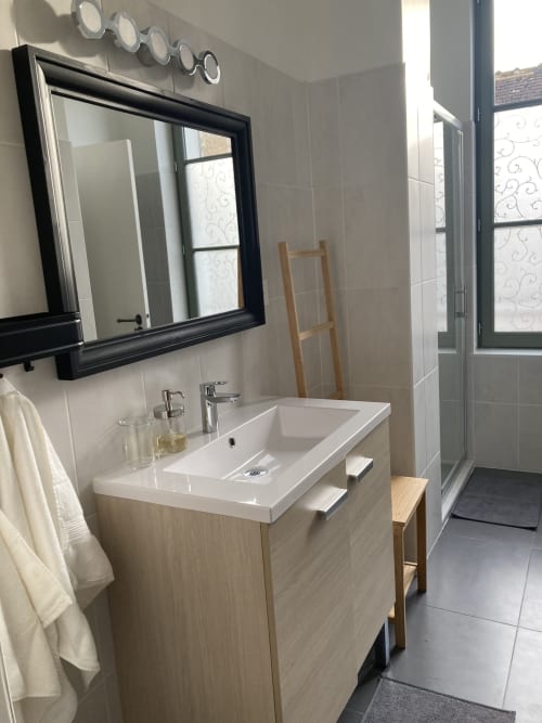 Salle de bains moderne de la chambre de l'hôtel Le relais de Touraine à Abilly, avec vasque, miroir noir et douche à l'italienne