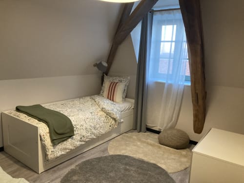 Chambre cosy au Relais de Touraine à Abilly : lit blanc, poutres apparentes, vue sur la ville et mobilier moderne