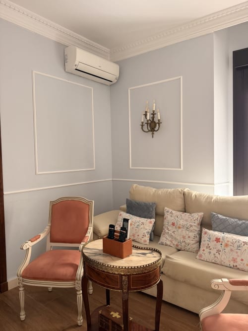 Elegante zona de estar en la Suite Giraldillo, hotel de Sevilla, con sofá crema, sillón terracota y decoración clásica