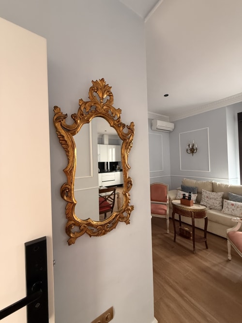 Espejo barroco dorado ornamentado en Suite Giraldillo de Edificio San Esteban 16, Sevilla, reflejando sala con sofá crema