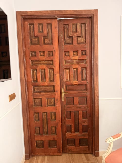 Puertas dobles de madera ornamentada con panelado detallado en la Suite Giraldillo del Edificio San Esteban 16, Sevilla