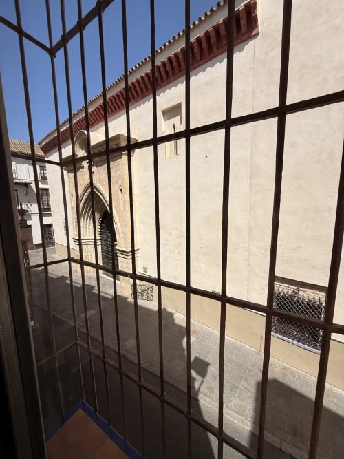 Vista de la catedral histórica a través de la reja de hierro desde el balcón de la Suite Giraldillo del hotel Edificio San Esteban 16 en Sevilla
