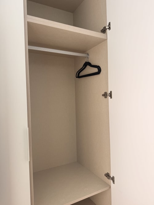 Armario de madera vacío con estantes y percha negra en suite del hotel Edificio San Esteban 16, Sevilla