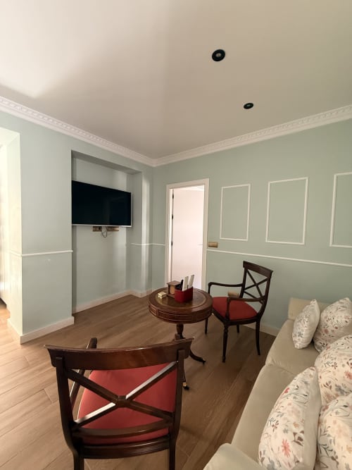 Sala moderna en la Suite Julio César del Edificio San Esteban 16, Sevilla, con sofá cama, sillas de comedor, mesa redonda y