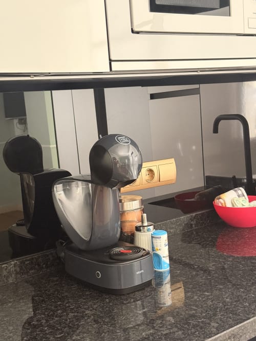 Cafetera Krups negra en la encimera oscura de la cocina de la suite del hotel de Sevilla con microondas y electrodomésticos