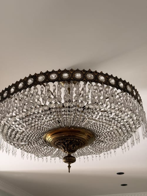 Lámpara de araña de cristal ornamentado con corona decorativa de bronce en suite de hotel de Sevilla