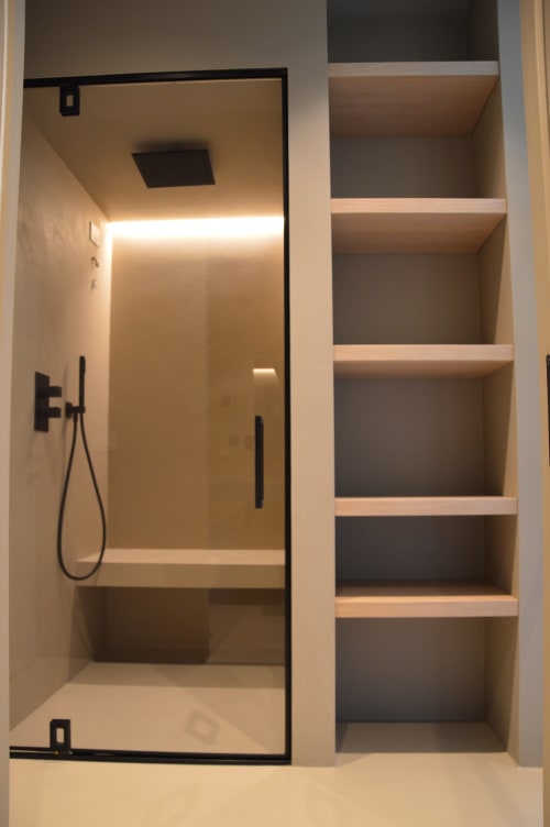 Bagno moderno con doccia walk-in, porta in vetro con cornice nera, scaffali in legno e illuminazione ambientale a Villa Rosati